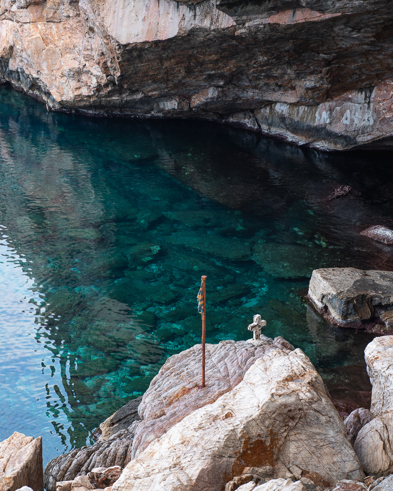 Calm water and a cross at the hike to  Agios Stefanos Chapel