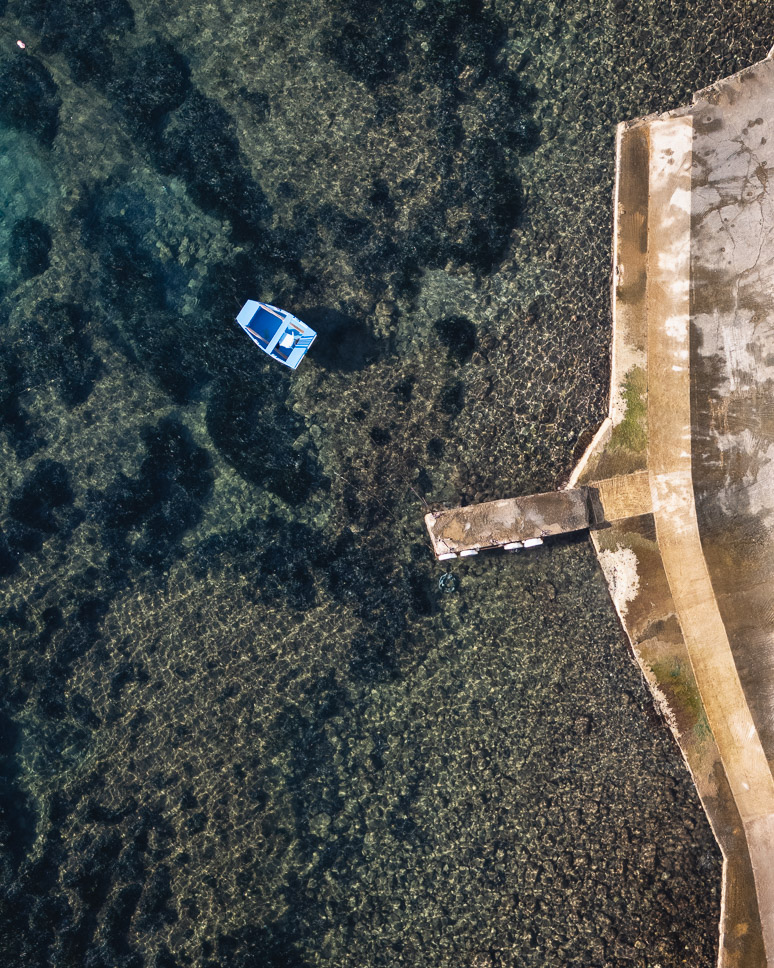 drone picture of a boat at the pier in Klima Beach