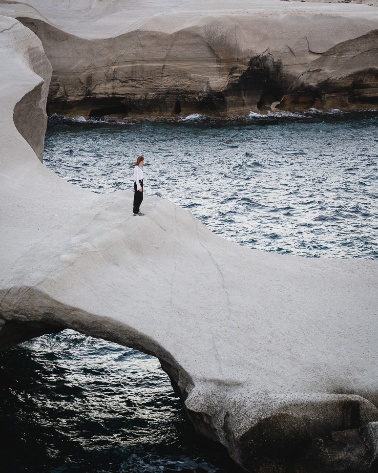 womand standing at one of the rocks in sarakiniko beach in Milos
