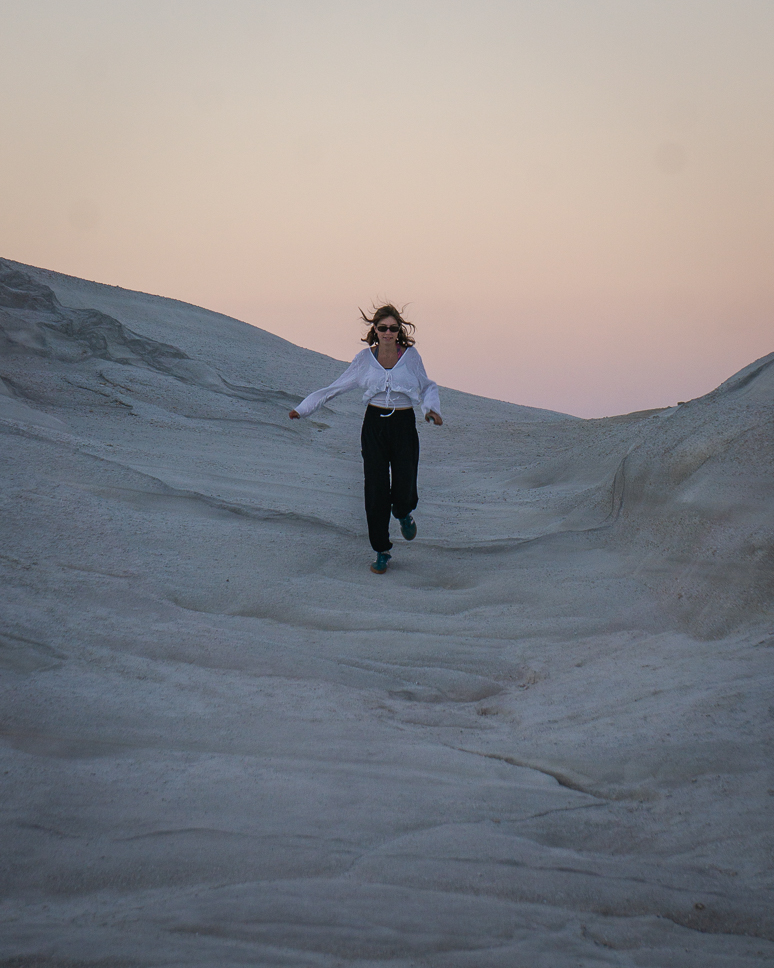 sarakiniko beach in Milos, girl running at sunset